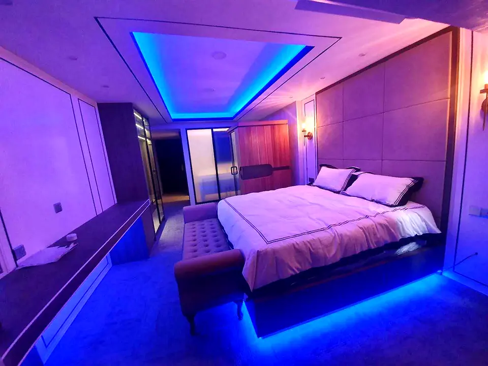 Bedroom with a panelled wall and LED lighting under the bed